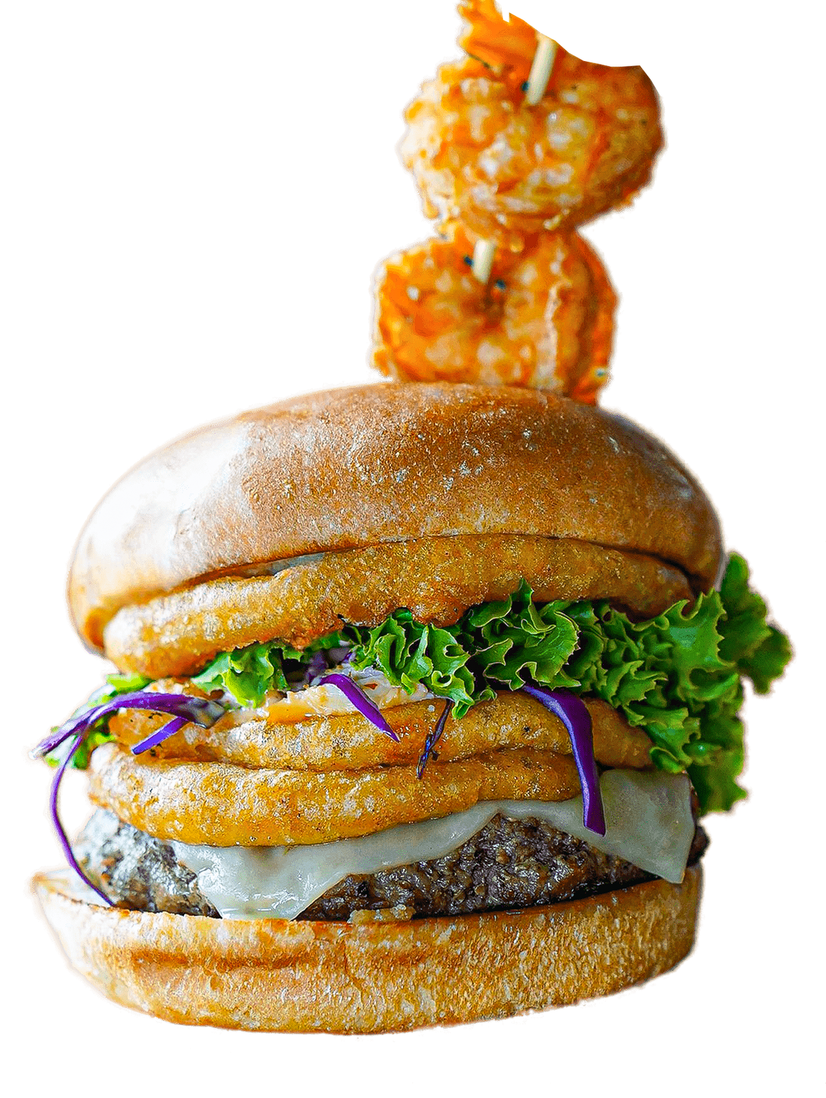 Mar y Tierra burger with onion rings, lettuce and shrimp on a skewer on top